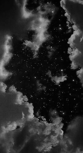 black and white photograph of clouds with stars in the sky