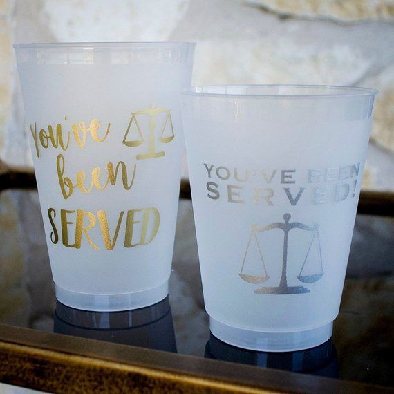 two plastic cups sitting on top of a table next to each other with writing on them