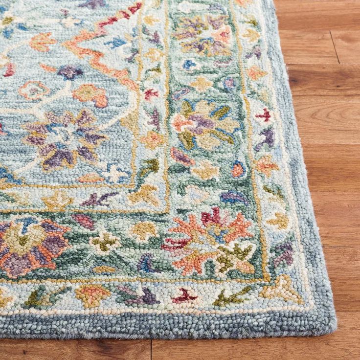 an area rug on the floor with wood floors in the background and a wooden floor