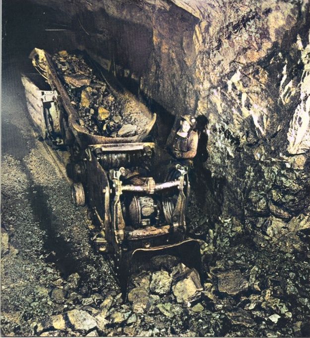 an old chair sitting in the middle of a cave filled with dirt and rocks,