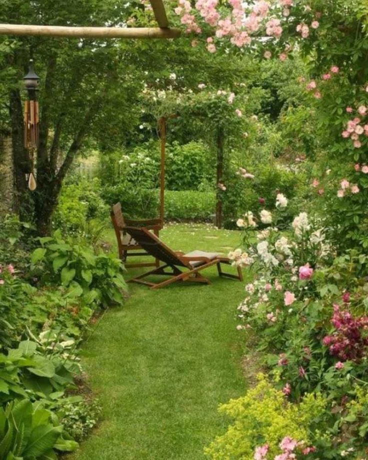 a wooden bench sitting in the middle of a lush green park filled with pink flowers