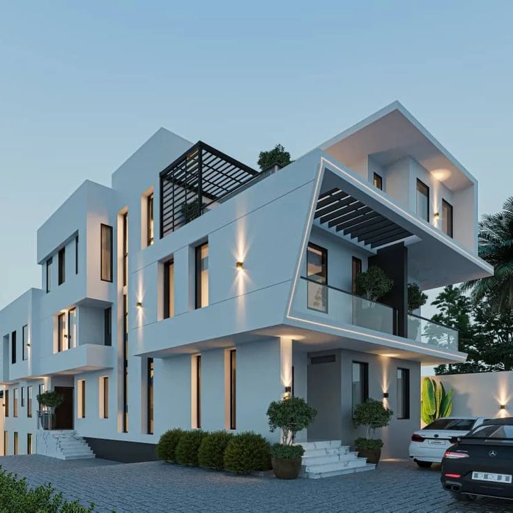 a white building with lots of windows and balconies on the top floor is lit up at night