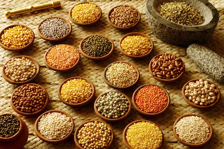 several bowls filled with different types of grains next to some spices and spoons on a table