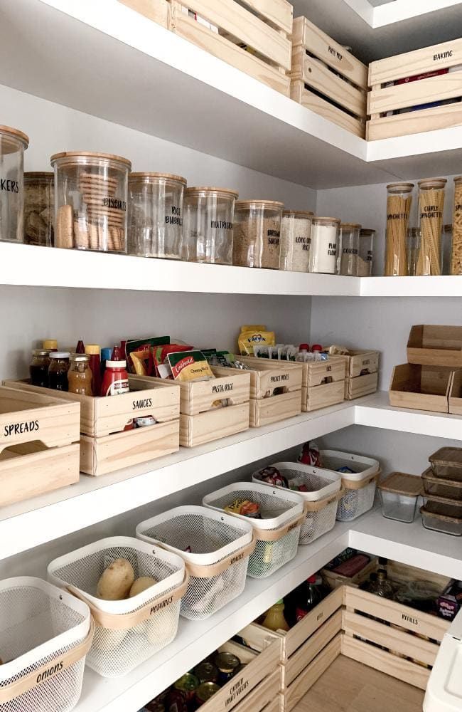 an organized pantry filled with lots of food and storage bins on shelving units