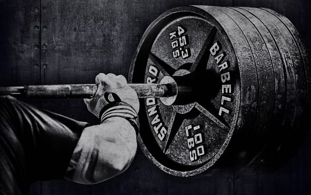 a man is lifting a barbell in the gym