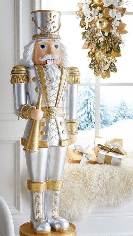 a large metal nutcracker standing in front of a window with christmas decorations on the windowsill