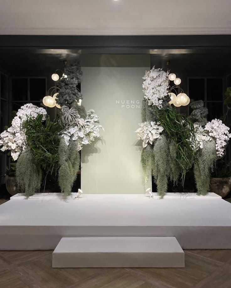 two vases filled with white flowers sitting on top of a table