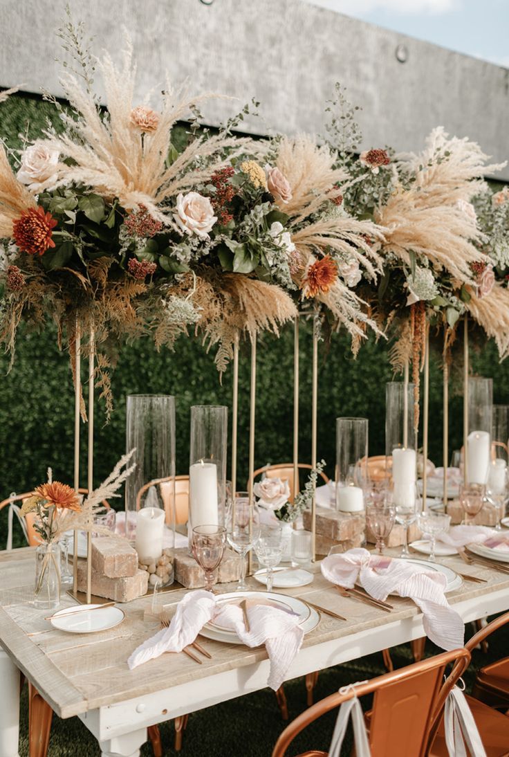 the table is set with candles, flowers and napkins for an elegant wedding reception