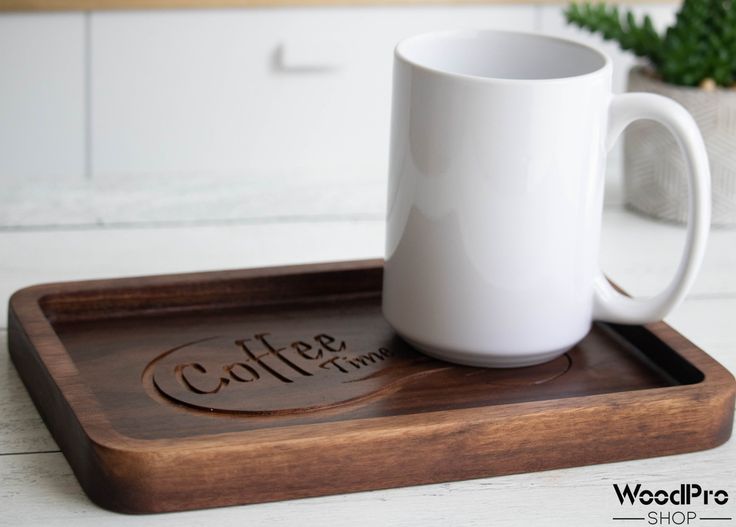 a white coffee mug sitting on top of a wooden tray