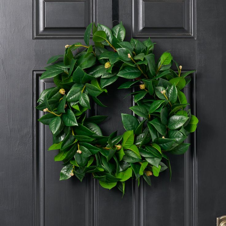 a green wreath is hanging on the front door