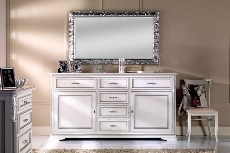 a white dresser and mirror in a room with carpeted flooring on the floor