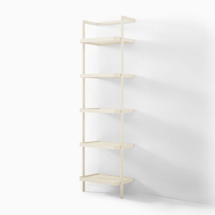 a white shelf with three shelves on each side and one is leaning against the wall