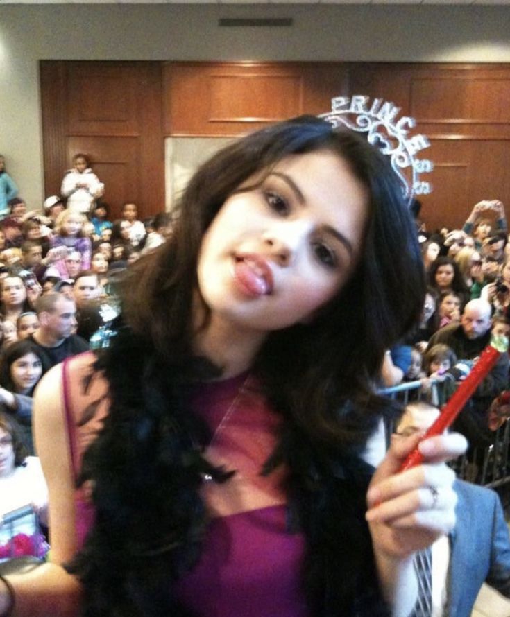 a woman holding a red toothbrush in front of a crowd