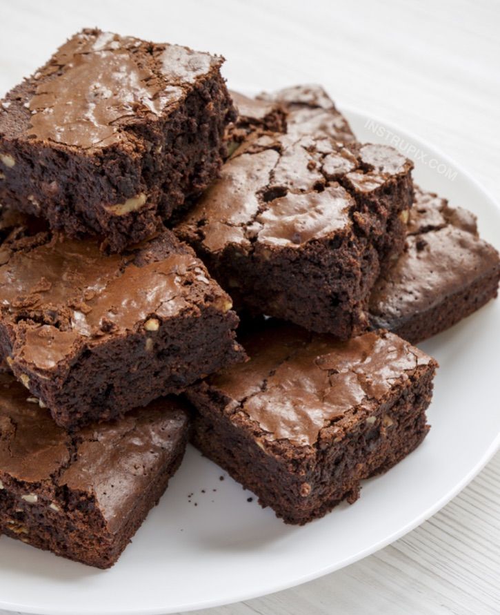 a white plate topped with brownies covered in frosting