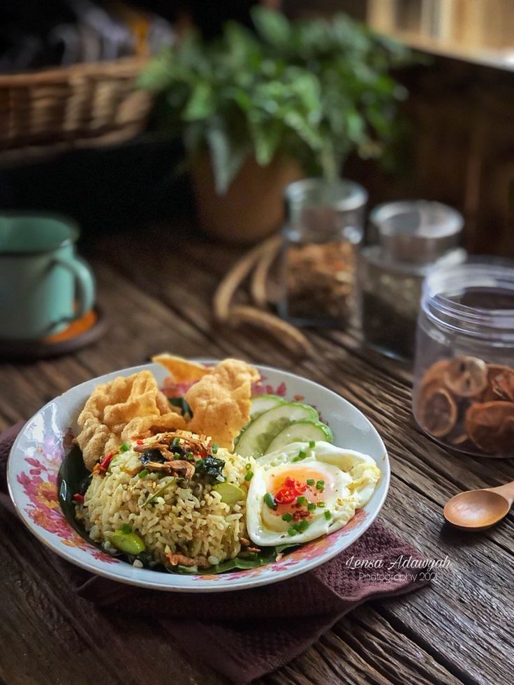 a bowl filled with rice and vegetables on top of a wooden table