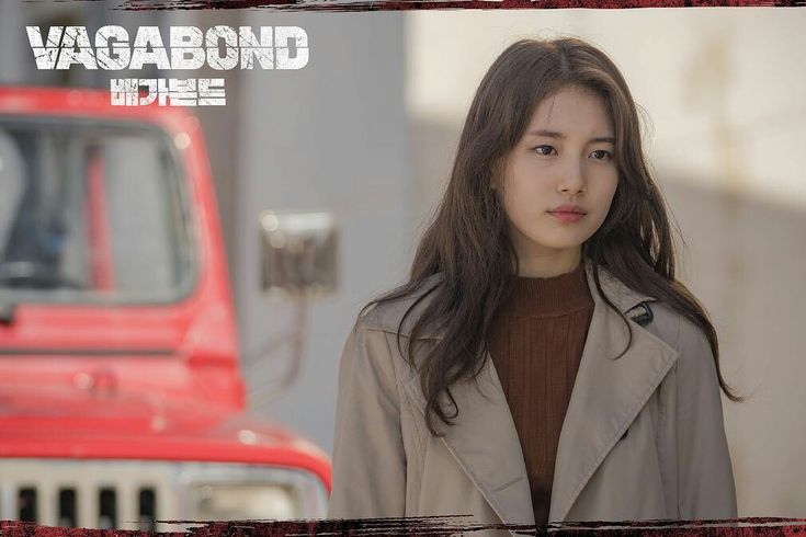 a woman standing in front of a red truck with the words vagabond on it