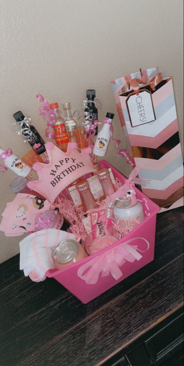 a pink gift box filled with lots of personal care items on top of a wooden table