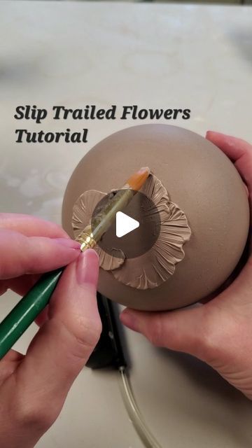 someone is painting an easter egg with flowers on the side and writing how to paint it