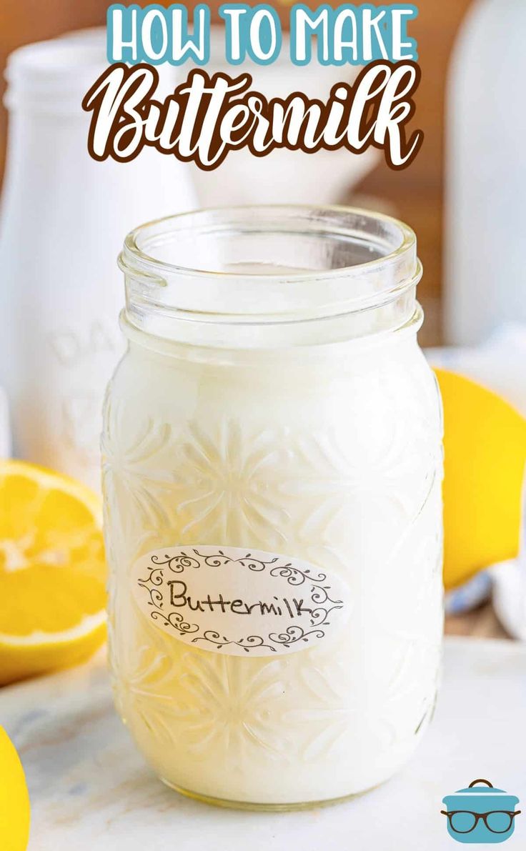 a mason jar filled with buttermilk sitting on top of a table next to lemons