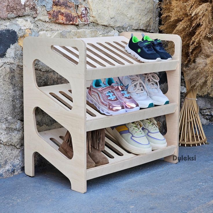 three pairs of shoes are sitting on a wooden shoe rack