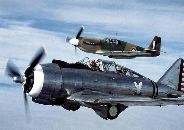 an air plane flying through the sky with people in it's cockpit and american flag on its wing