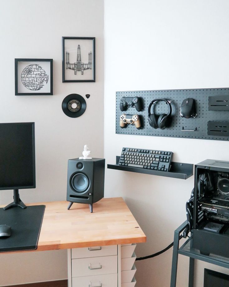 there is a computer on the desk with speakers and headphones hanging above it, along with other electronic equipment