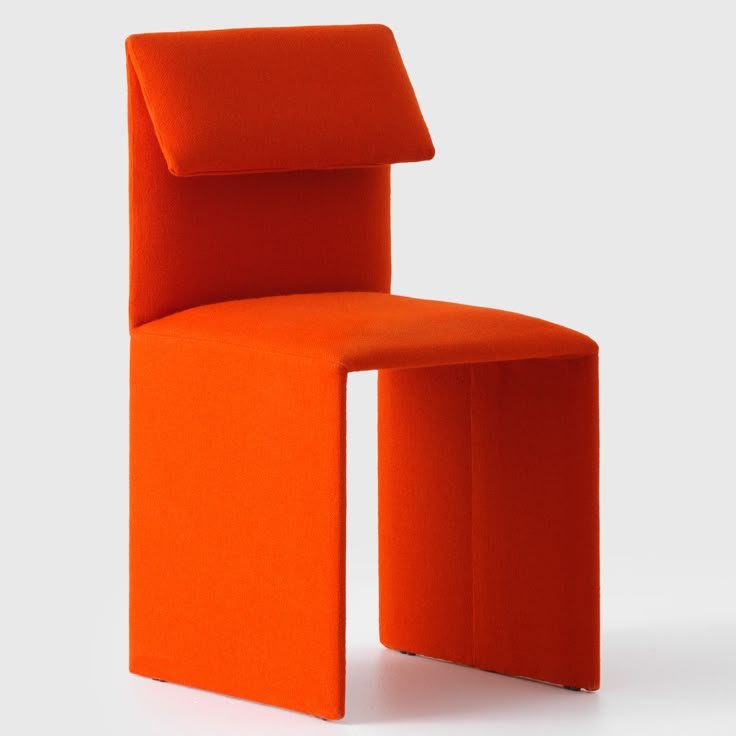 an orange chair sitting on top of a white floor