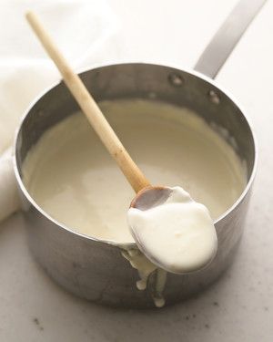 a wooden spoon in a pan filled with milk