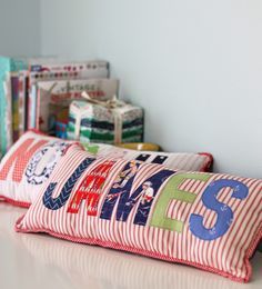 two red and white striped pillows sitting on top of a counter next to bookshelves