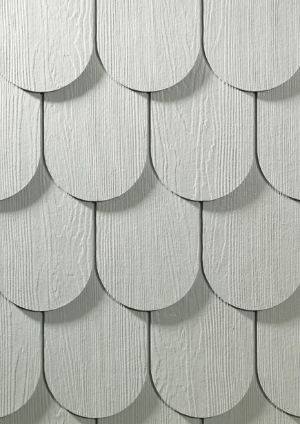 white wood shingles are arranged on the side of a building in an abstract pattern