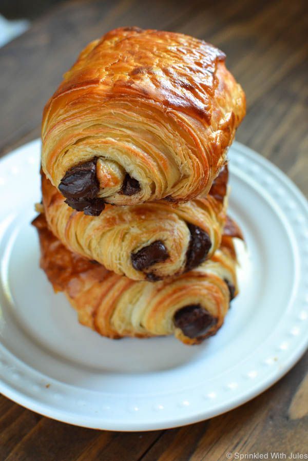 two croissants are stacked on top of each other on a white plate