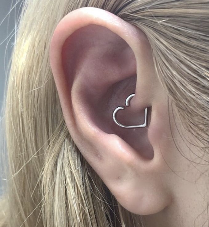 a close up of a person's ear with a heart shaped nose piece in the middle