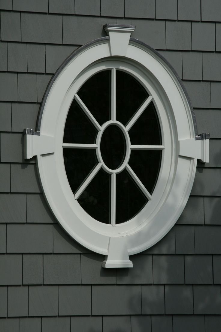 a round window on the side of a gray brick building