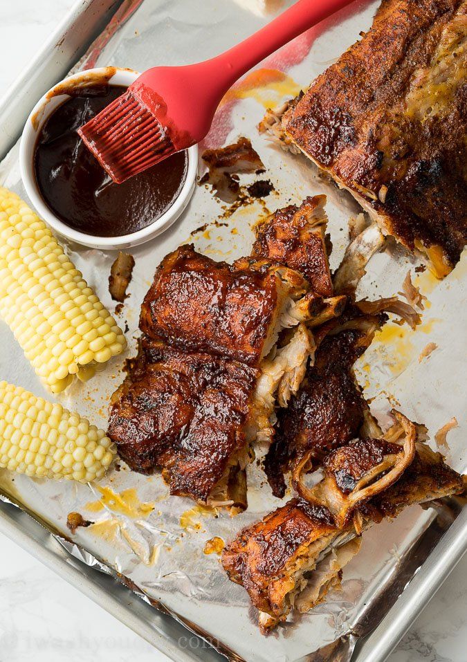 ribs, corn and barbecue sauce on a tray