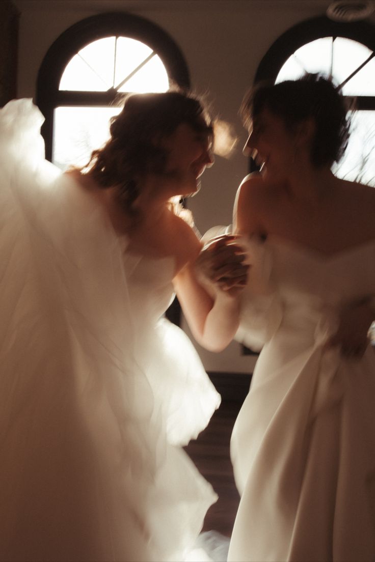 two women in white dresses standing next to each other