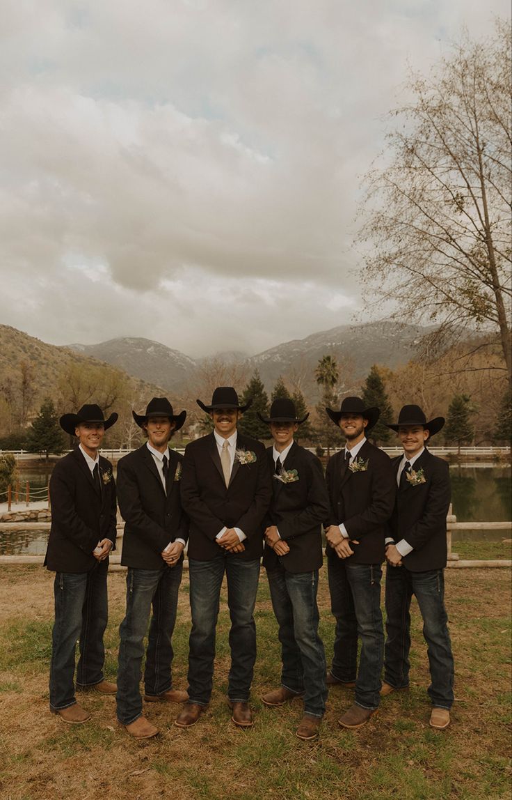 a group of men standing next to each other wearing cowboy hats