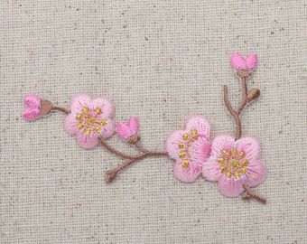 pink flowers are embroidered onto the fabric