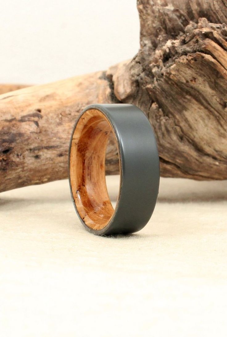 a wooden ring sitting on top of a table next to a piece of driftwood