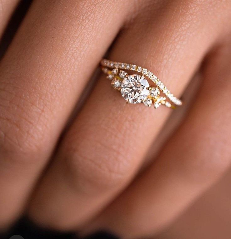 a woman's hand with a diamond ring on her finger and an engagement band