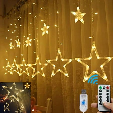 a person holding a remote control in front of a string of stars hanging from the ceiling