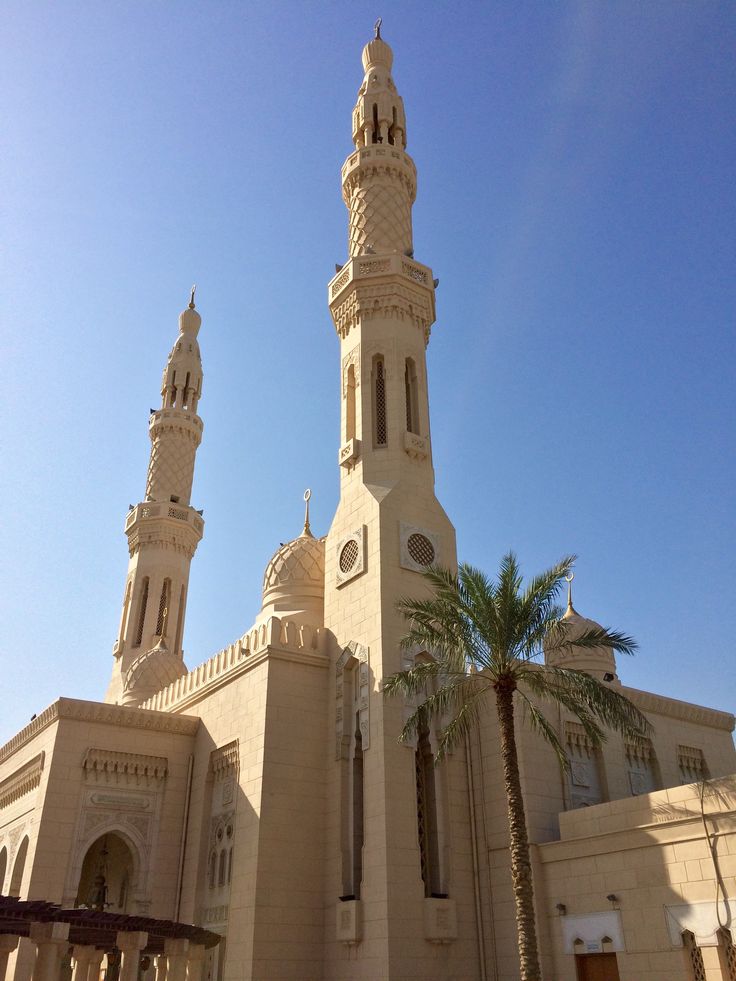 a large white building with two towers and palm trees