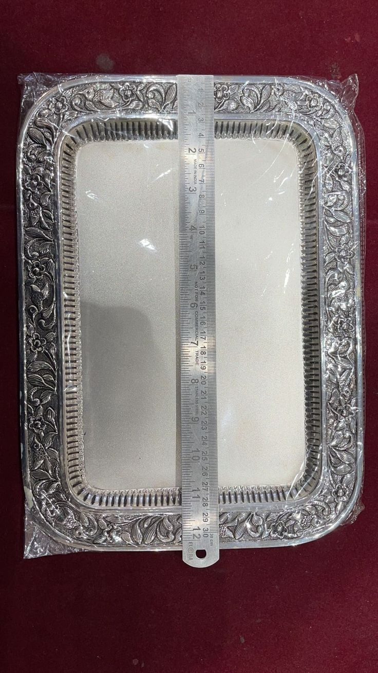 a silver plate with a measuring tape on it's side and the bottom half cut off