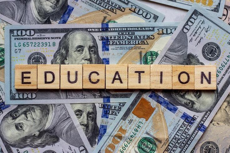 the word education spelled with wooden blocks on top of hundred dollar bills stock photo edit