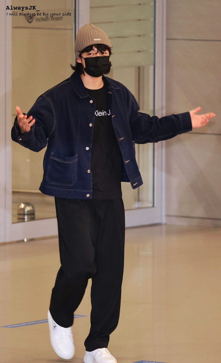 a man wearing a face mask while standing on top of a skateboard in an empty room