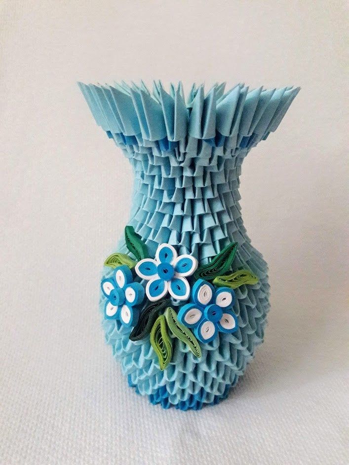 a blue vase with flowers on it sitting on a white tableclothed surface,