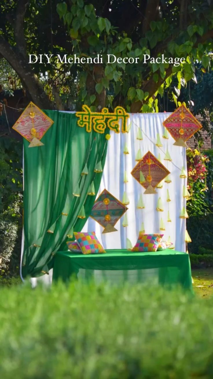 a green and white stage set up in the middle of some grass with decorations on it