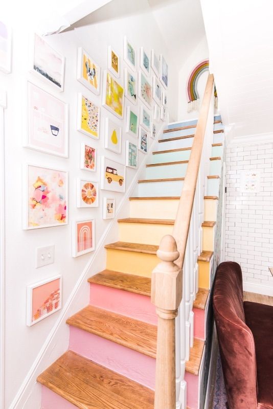 there is a stair case with pictures on the wall and pink carpeted stairs in front of it