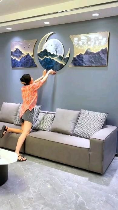 a woman standing on top of a couch in a living room