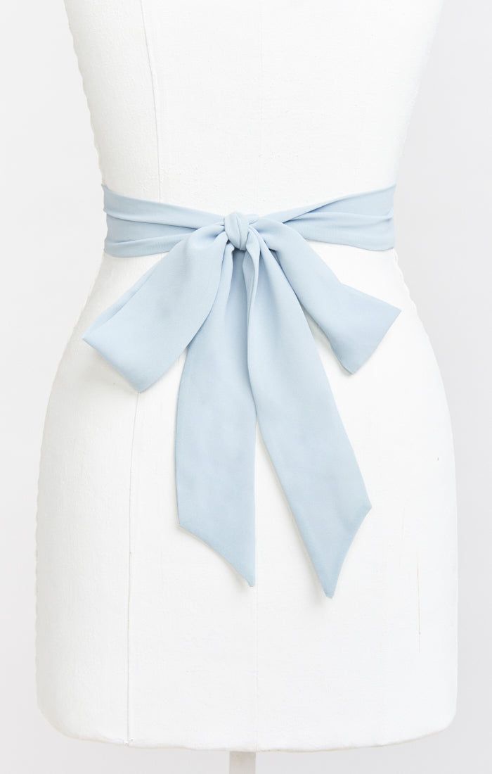 a white dress with a light blue sash on it