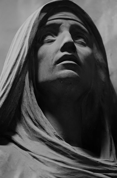 black and white photograph of jesus statue with head covered in cloths, looking upward